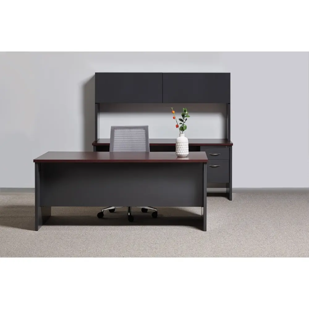 Desk with dark gray file pedestal and light wood top, in an open space
