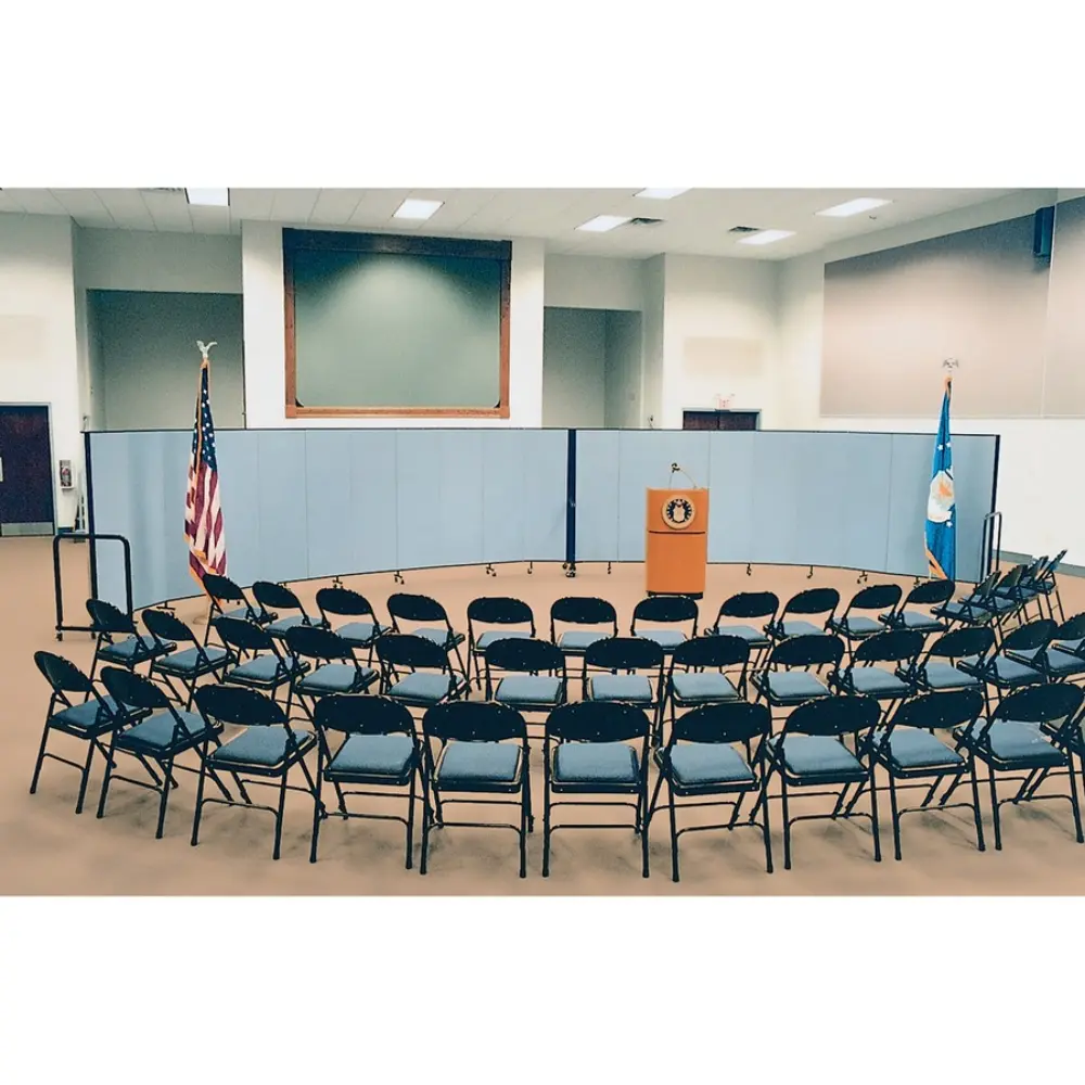 Multiple grey folding panels on wheels forming a curved partition