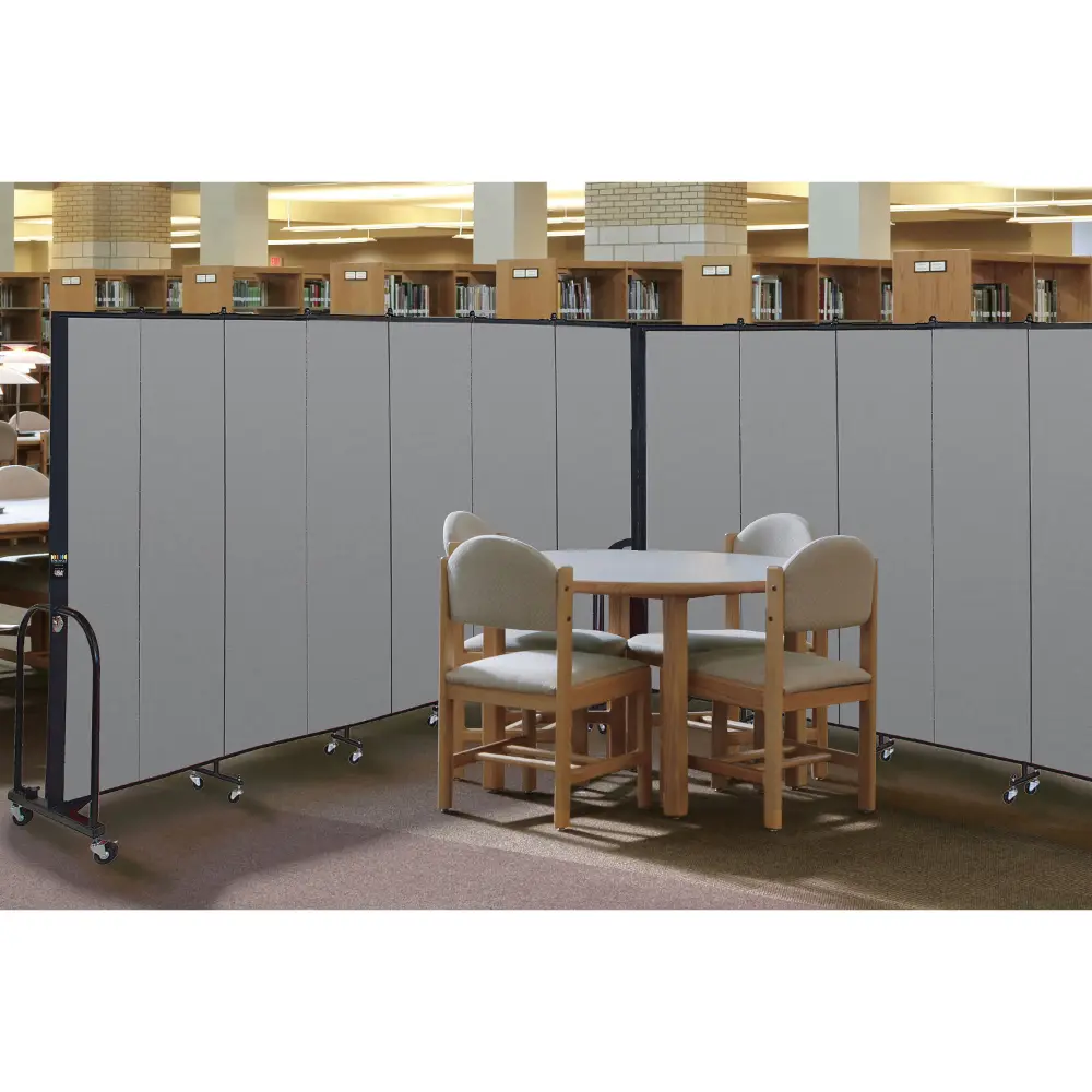 A long grey folding screen on wheels used as a room divider in a large hall