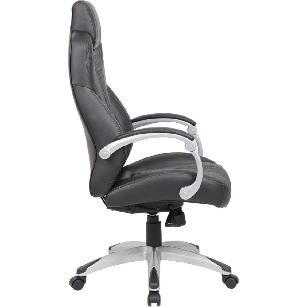 Office setup showing black quilted chair at desk in a modern office with shelves and printer
