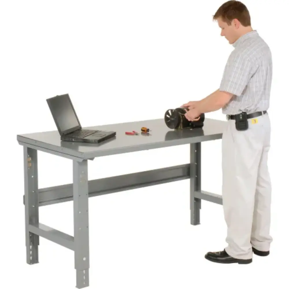 Person standing by workbench with laptop and tool, usage scenario