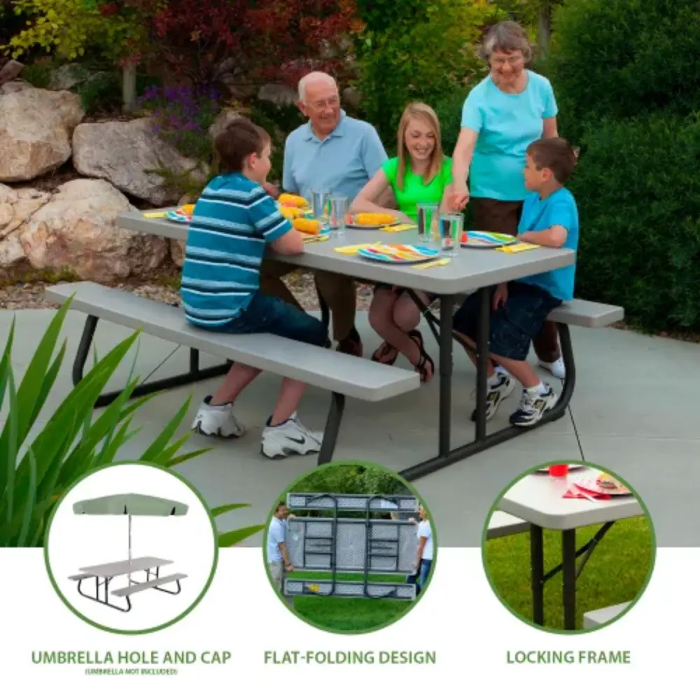 Family gathered around a grey picnic table set for a meal in a yard