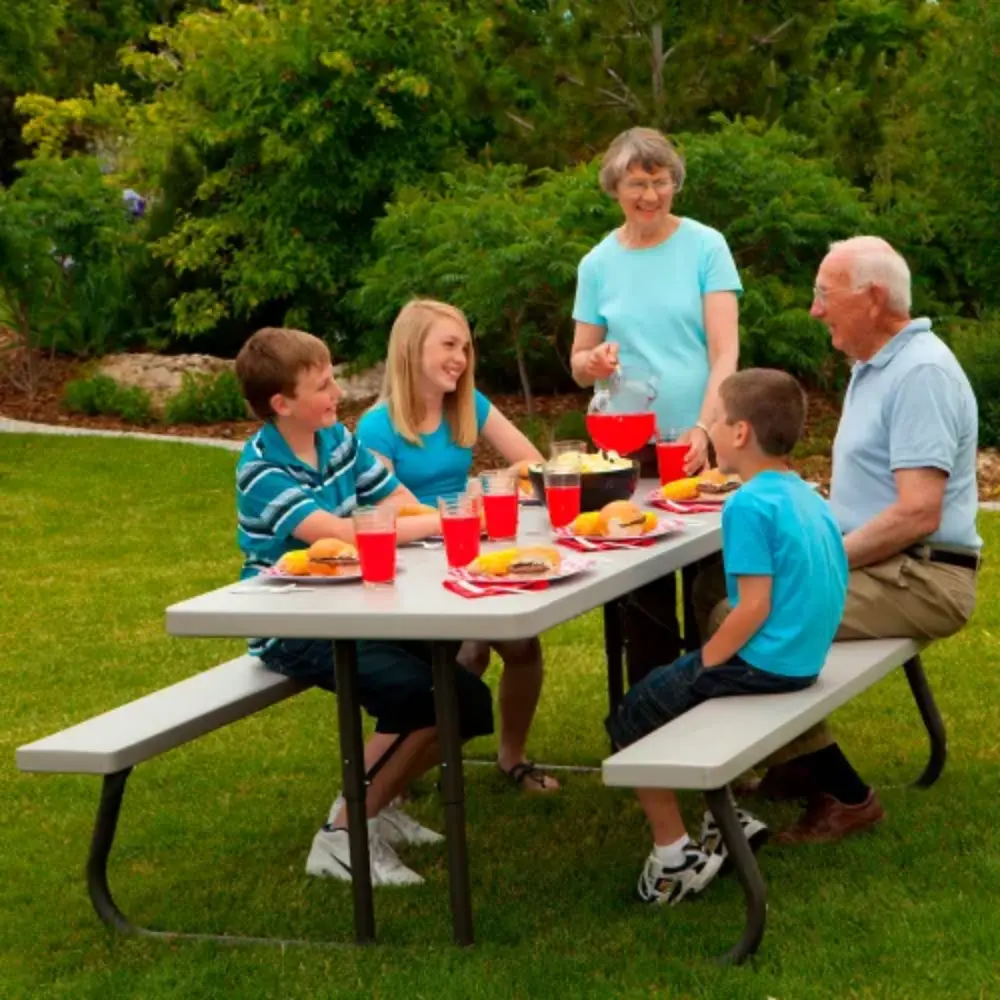 Family outdoor meal at a grey picnic table on a lawn